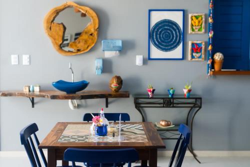 巴雷里尼亚斯Pousada Vila de Charme的一间带木桌和蓝色椅子的用餐室