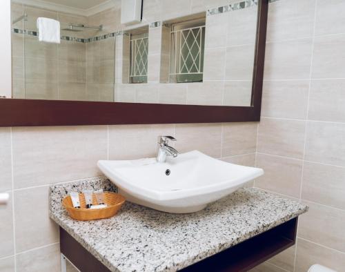 MasvingoGreat Zimbabwe Hotel的浴室设有白色水槽和镜子