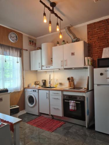 蓬塔德尔加达Cozy apartment close to airport的厨房配有白色橱柜和洗衣机。