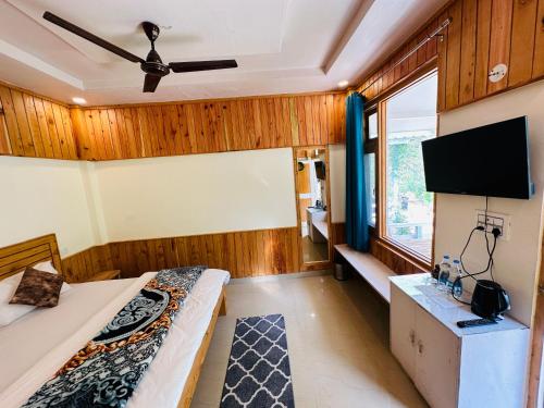 卡索尔The Stream Kasol的客房设有两张床和一台平面电视。