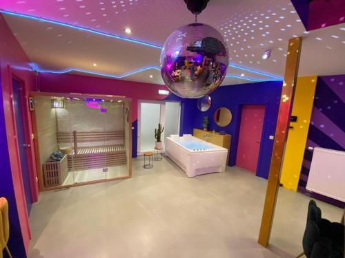 拉卢维耶尔Capsule Boogie-Woogie - JACUZZI - SAUNA - BILLARD - JEUX - ECRAN GÉANT - FILET SUSPENDU - NETFLIX的紫色的客房配有浴缸和迪斯科舞厅