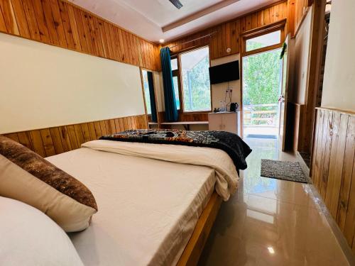 卡索尔The Stream Kasol的一间卧室设有两张床和大窗户
