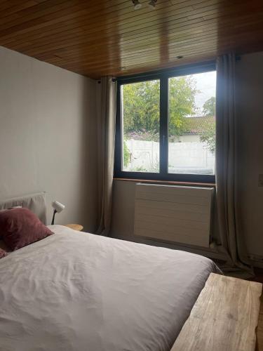 鲁汶Ingerichte woning met tuin的一间卧室设有一张大床和一个窗户。