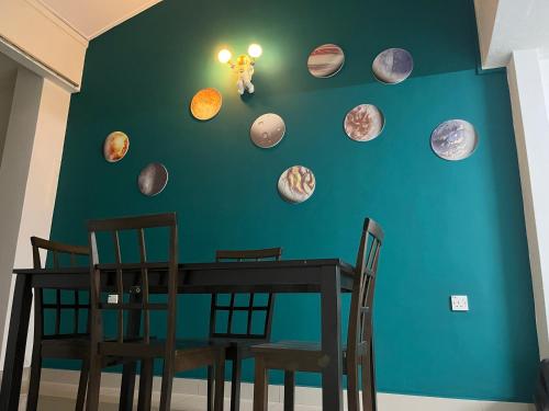 怡保Green Space Homestay Cozy Family(8-12pax)的一张餐桌,墙上挂着行星