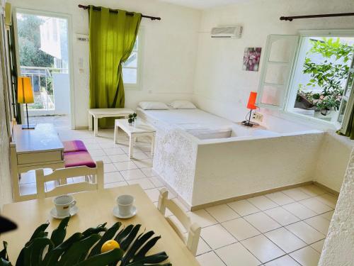 赫索尼索斯Optasia Apartments的配有一张床和一张桌子及椅子的房间