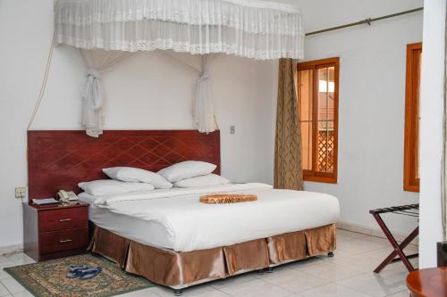 朱巴Aron International Hotel的一间卧室配有一张带白色床单的大床