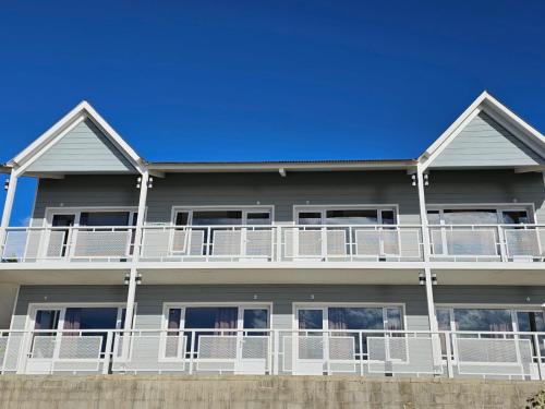埃尔卡拉法特Bahia Rooms的白色阳台和蓝色天空的房子