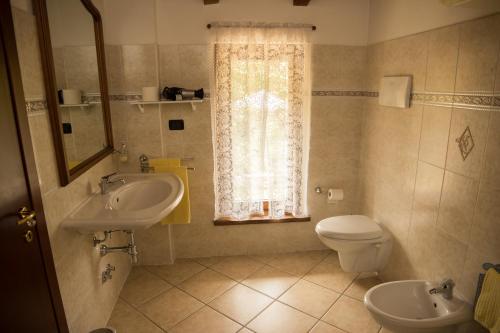 里韦尔加罗曼德罗拉农庄民宿的一间带水槽和卫生间的浴室以及窗户。