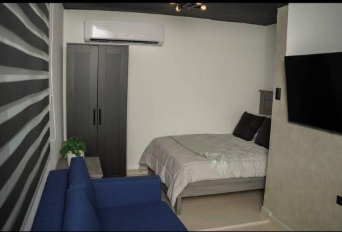 Toa BajaNorth Breeze Guest House 2的一间卧室配有一张床和一张蓝色的沙发