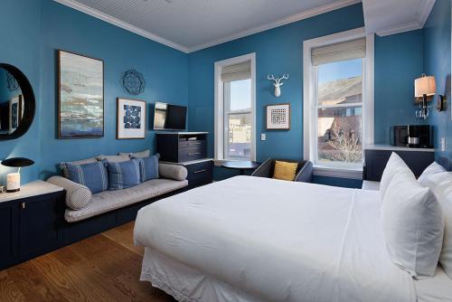 阿斯潘Independence Square 205, Stylish Hotel Room with AC, Great Location in Aspen的蓝色的卧室设有一张大床和一张沙发