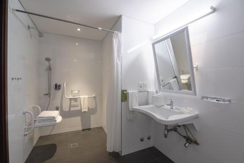 蒙得维的亚蒙得维的亚希尔顿花园酒店的白色的浴室设有水槽和镜子