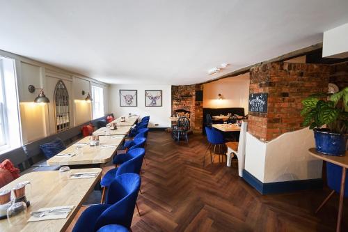 瓦灵福德The Royal的餐厅设有长桌和蓝色椅子