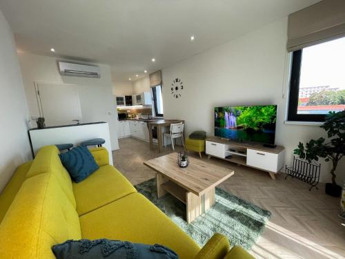 科希策Luxury City Retreat with Terrace的客厅设有黄色沙发和电视