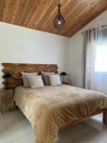 萨拉济Les lodges de Salazie的一间卧室设有一张大床和木制天花板