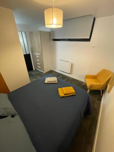 圣布里厄Gare australe的配有床和黄色椅子的房间