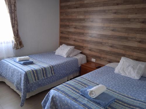 纳塔列斯港Hostal JC的木墙客房的两张床