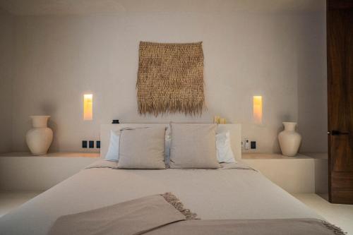 图卢姆Nãmas Tulum的一间卧室配有带白色床单和枕头的床。