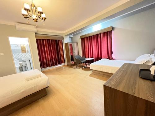 加德满都Boudha Apart Hotel的酒店客房设有两张床和吊灯。