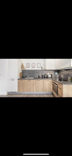 索利赫尔Solihull Town Centre Spacious Studio Apartment的厨房配有木制橱柜和不锈钢用具