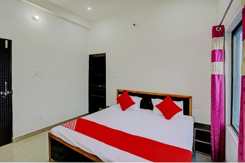 瓦拉纳西OYO Flagship Hotel Bhardwaj的卧室配有带红色枕头的白色床