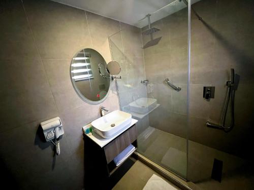 IkogosiIKOGOSI WARM SPRINGS RESORT的浴室配有盥洗盆和带镜子的淋浴