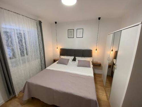 锡尼Apartman "Borićevac"的卧室配有白色的床和窗户。
