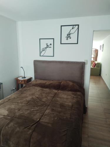 科尔多瓦Makipura的一间卧室配有一张大床,墙上有两张照片