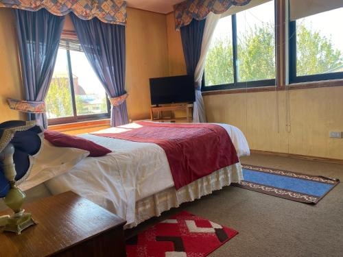 瓦尔迪维亚Hostal Buenaventura的一间卧室设有一张床、一台电视和窗户。