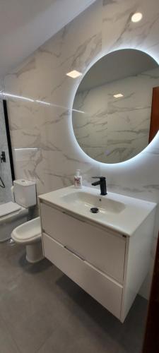 拉赫Apartamento Xanela o Mar的白色的浴室设有水槽和镜子