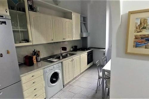 罗马Cozy flat in Testaccio的厨房配有白色橱柜和洗衣机。