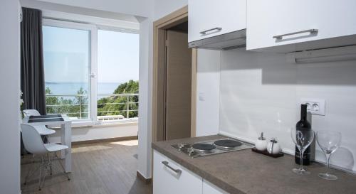 米利尼Comfort Zovko的厨房配有带水槽的柜台和窗户。