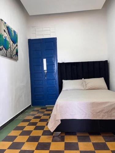 圣多明各APARTAMENTO ZONA COLONIAL R的一间卧室配有一张床和一个蓝色的门