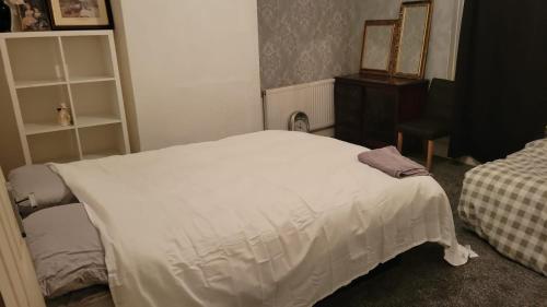 奥尔德姆234 Belgrave的卧室配有白色的床和梳妆台。