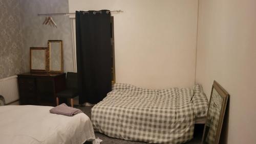 奥尔德姆234 Belgrave的一间卧室配有一张床、梳妆台和镜子