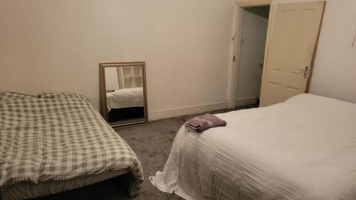 奥尔德姆234 Belgrave的一间卧室配有两张床和镜子