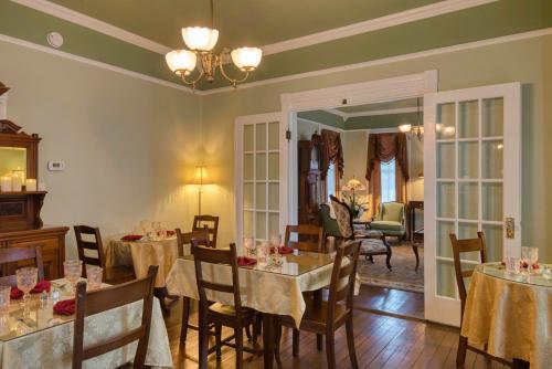 圣奥古斯丁Victorian House Bed and Breakfast的一间带桌椅的用餐室和一间房间