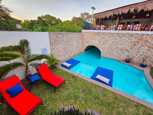 巴利亚多利德Mayan Majesty Boutique Hotel的后院设有两把椅子和游泳池