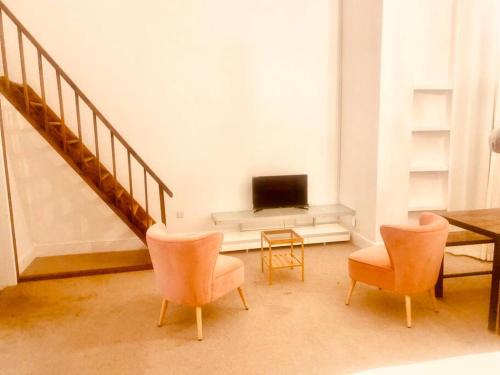 伦敦Large self-contained cozy studio的客厅配有电视和桌椅