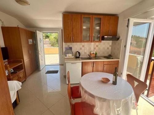 萨利Apartments by the sea Sali, Dugi otok - 8110的厨房配有一张桌子,上面有白色的桌布