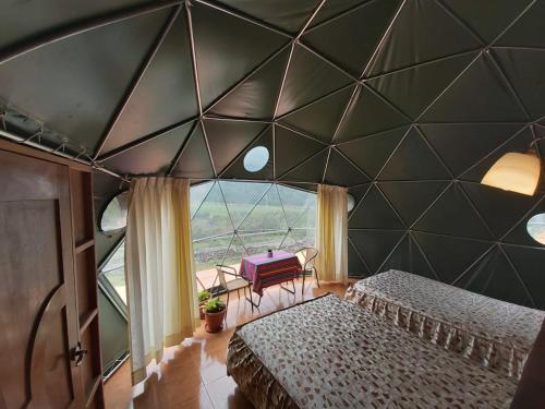SoraySky Lodge Domes Salkantay的一间卧室设有两张床和大窗户