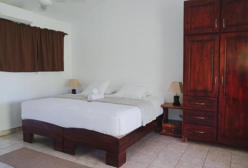 科克Hotel Villa Del Sol的卧室配有白色的床和木制橱柜。