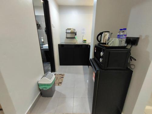 话毛生Hanan Studio Apartment with Pool, Wifi & Netflix的厨房配有黑色冰箱和白色瓷砖地板。