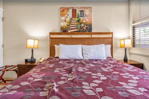 维雷亚Kamaole Sands 2-306- Kamaole Sands spacious, updated, and Oceanview!的一间卧室配有一张床、两盏灯和一幅画