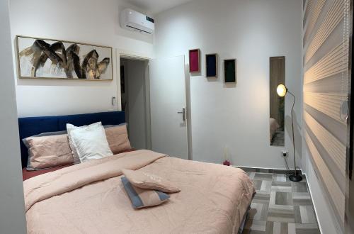 布拉柴维尔SYN - Corniche的一间卧室配有一张蓝色床头板的床