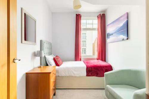 达灵顿Paradise House Darlington的一间卧室配有一张带红色窗帘的床和一扇窗户