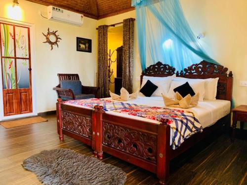 瓦尔卡拉Maadathil Cottages & Beach Resort的一间卧室配有一张蓝色天蓬大床