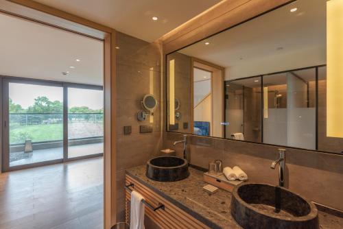 上海上海百万石温泉酒店的一间带两个盥洗盆和大镜子的浴室