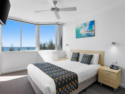 黄金海岸水手海岸俱乐部酒店的一间卧室设有一张床和一个大窗户
