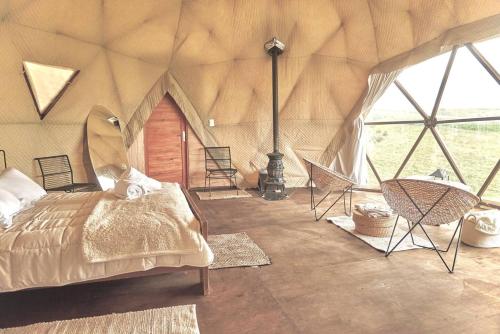 巴尔内阿里奥坎布宜诺斯艾利斯FARMGLAMP的一间卧室,在帐篷里配有一张床和椅子