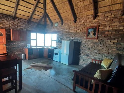 Gobabis西巢小屋旅馆的客房设有带冰箱和桌子的厨房